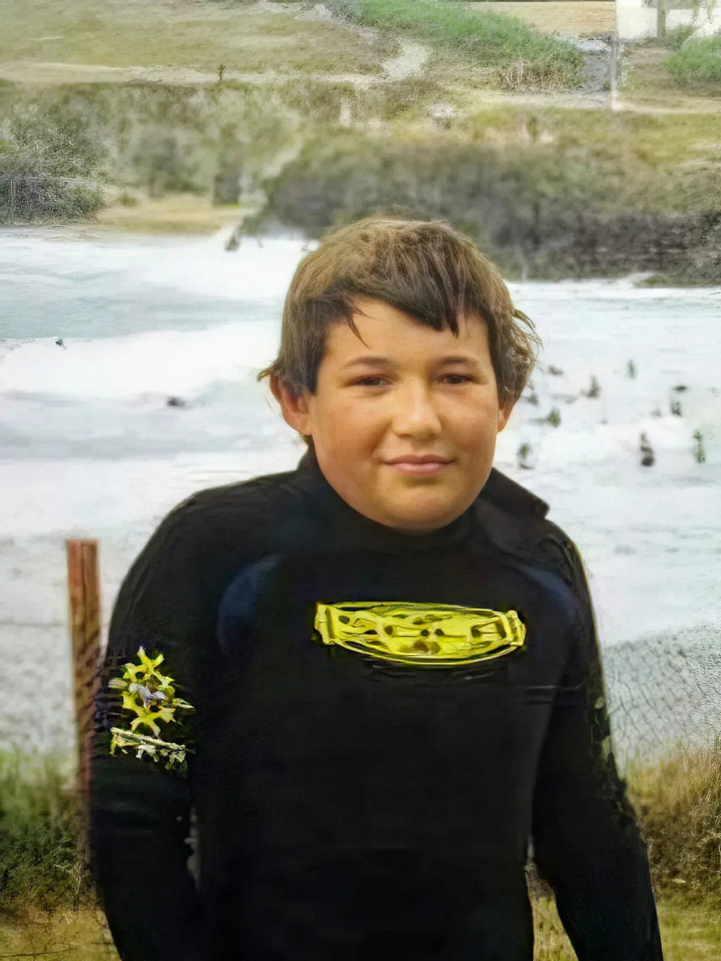Young Tom in a wetsuit on the beach